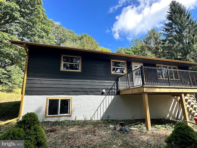 rear view of property featuring a wooden deck