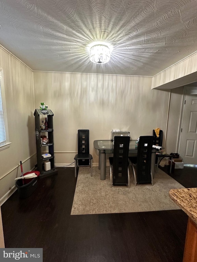 dining space with wood-type flooring and wood walls