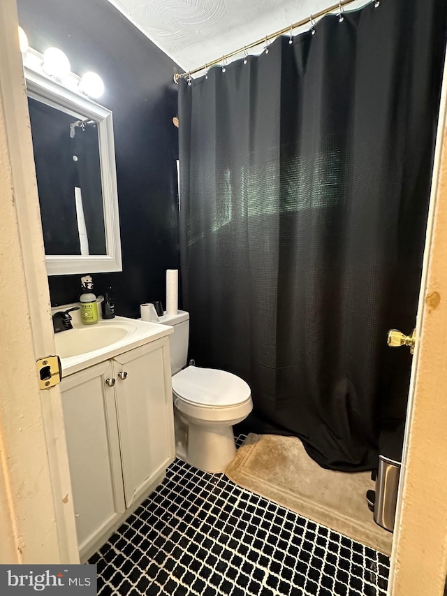 bathroom featuring a shower with shower curtain, tile patterned floors, vanity, and toilet