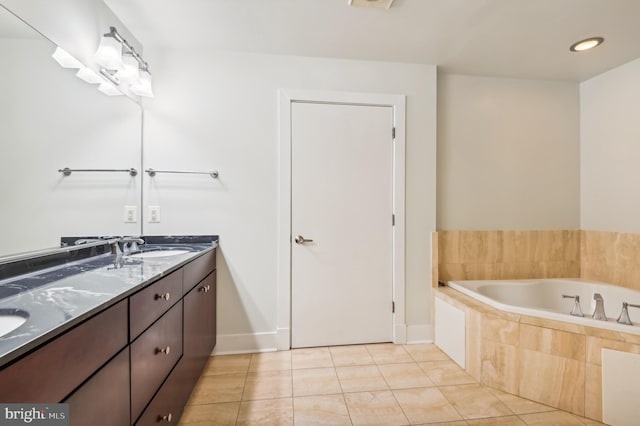 bathroom featuring tile patterned floors, vanity, and tiled bath