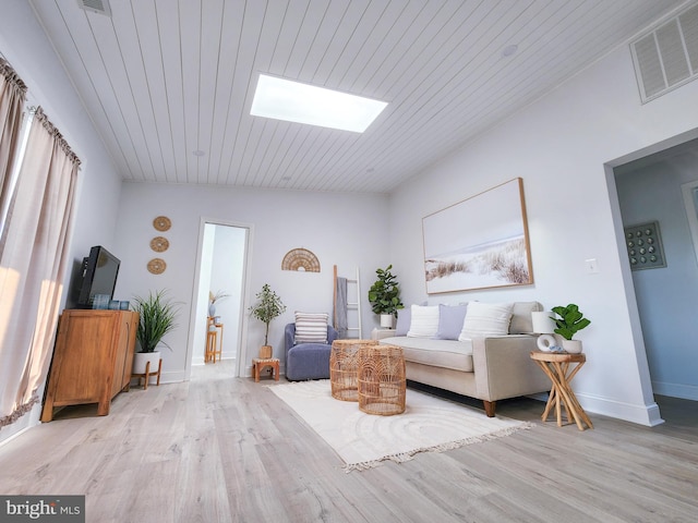 sitting room with wooden ceiling, a skylight, light wood-style flooring, and visible vents