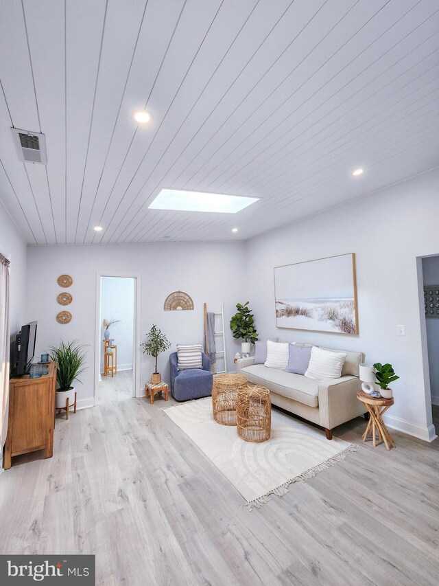 living room featuring wood ceiling, hardwood / wood-style flooring, and a skylight