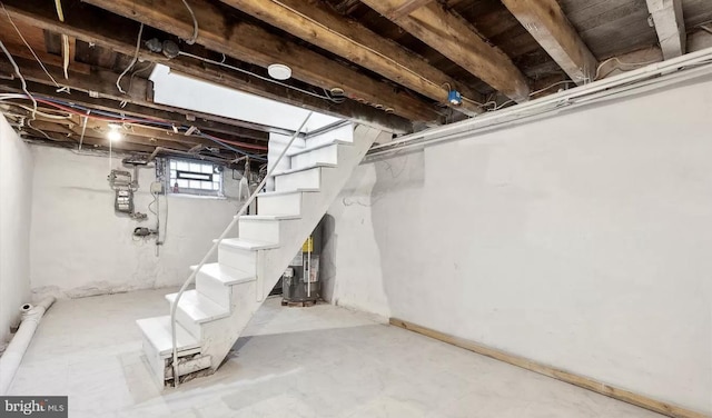 basement featuring stairs and water heater