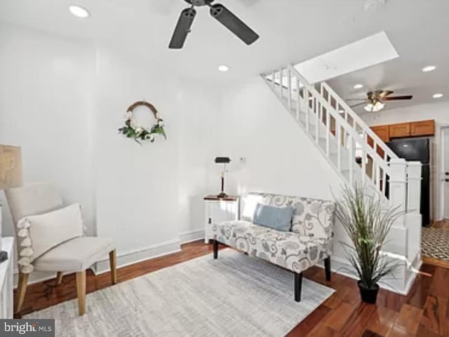 living area with ceiling fan and dark hardwood / wood-style flooring