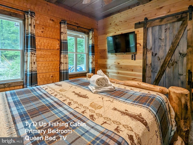 bedroom featuring hardwood / wood-style floors, a barn door, wooden ceiling, and wood walls