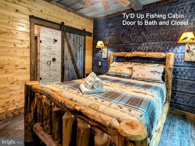 bedroom featuring wood walls, hardwood / wood-style floors, a barn door, and wooden ceiling