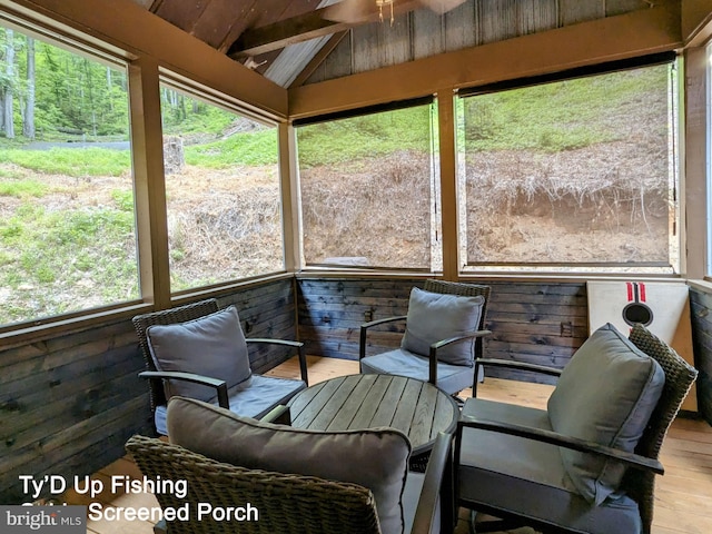 sunroom featuring lofted ceiling with beams and plenty of natural light