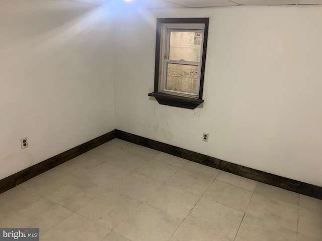 unfurnished room with baseboards