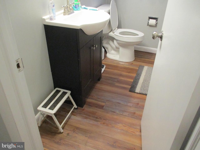 bathroom featuring vanity, toilet, and hardwood / wood-style floors