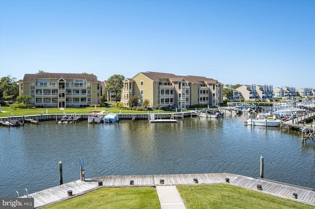 dock area with a yard, a water view, and a residential view