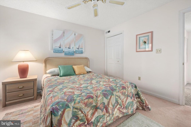 carpeted bedroom with ceiling fan, a textured ceiling, and a closet