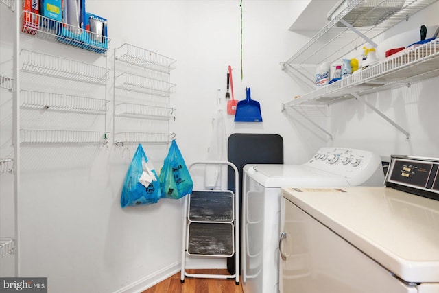 laundry room featuring wood-type flooring and washer and dryer