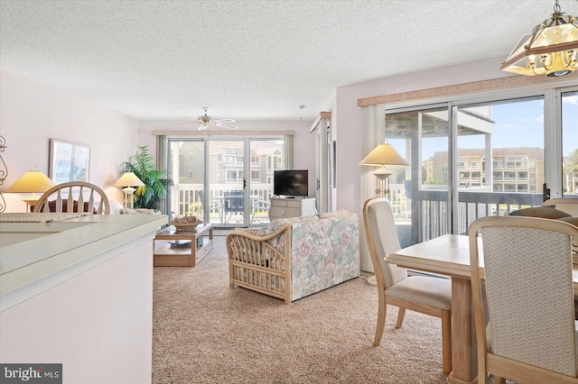 living room with a textured ceiling, a healthy amount of sunlight, and ceiling fan