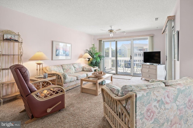 carpeted living room featuring ceiling fan and a textured ceiling