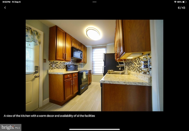 kitchen featuring black appliances, sink, and decorative backsplash