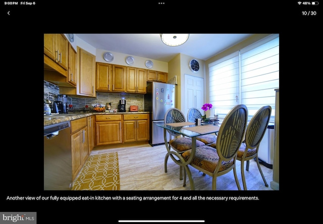 kitchen featuring stainless steel appliances, dark stone countertops, and tasteful backsplash