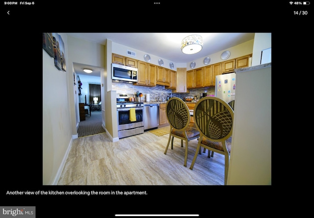 kitchen with appliances with stainless steel finishes and tasteful backsplash