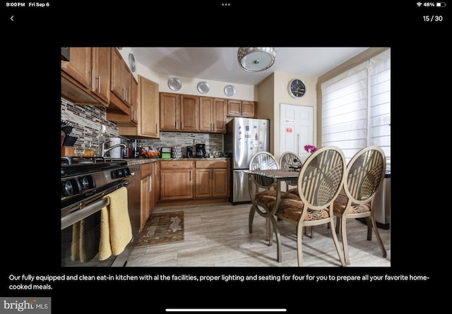 kitchen with stainless steel appliances, dark stone countertops, and decorative backsplash