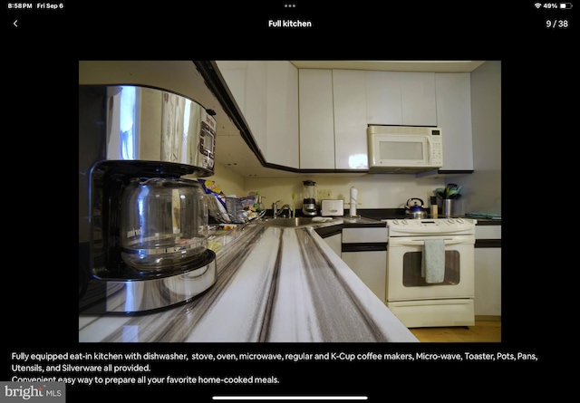 kitchen featuring white cabinetry, white appliances, light hardwood / wood-style flooring, and sink