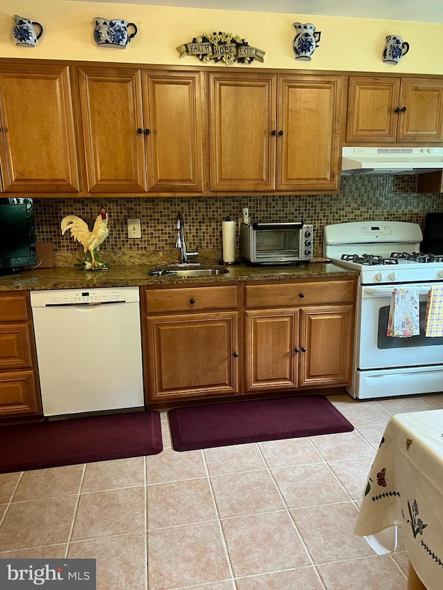 kitchen featuring white appliances, decorative backsplash, light tile patterned flooring, and sink