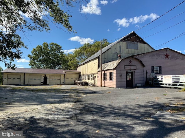 exterior space with an outbuilding, a garage, and metal roof