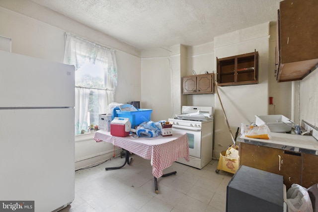 kitchen with white appliances and a textured ceiling