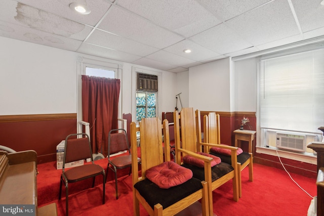 sitting room with cooling unit, carpet, and a drop ceiling