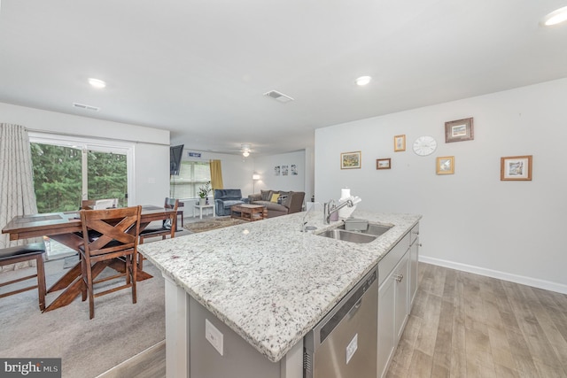 kitchen featuring light hardwood / wood-style floors, dishwasher, a center island with sink, and sink