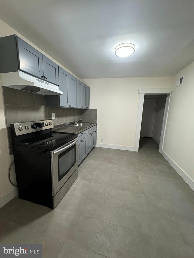 kitchen featuring stainless steel electric range oven, sink, and decorative backsplash