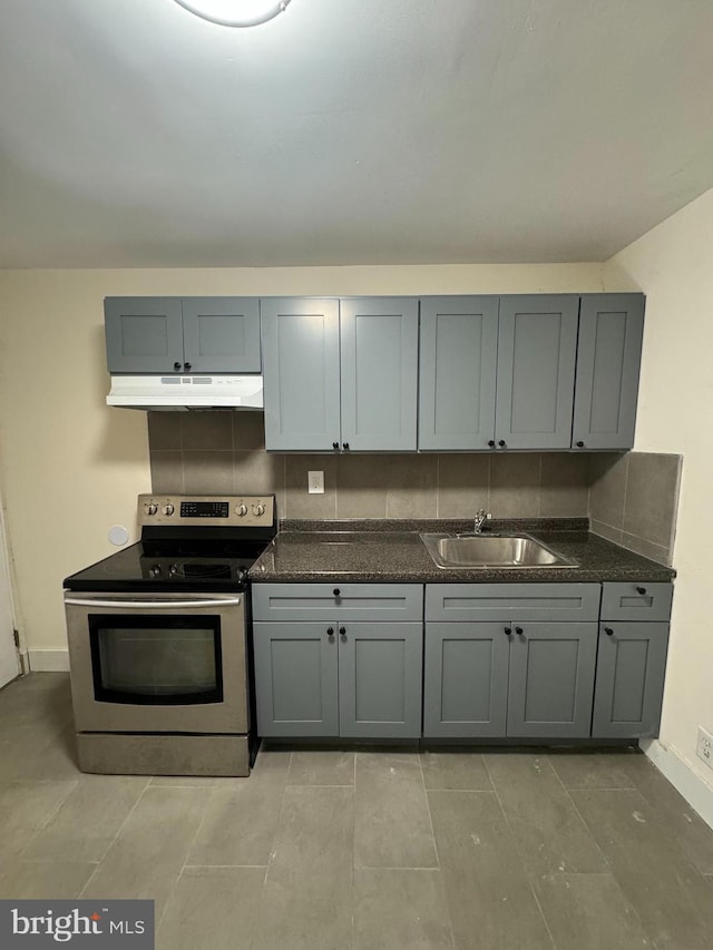 kitchen with backsplash, gray cabinetry, under cabinet range hood, stainless steel electric range oven, and a sink