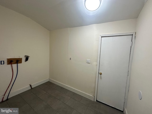 laundry area featuring dark tile patterned floors, laundry area, and baseboards