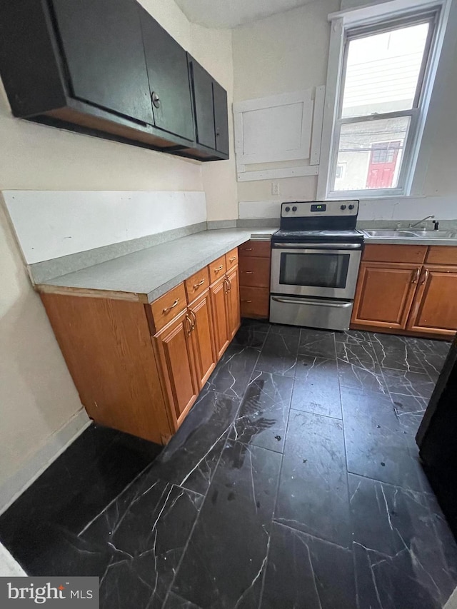 kitchen with light countertops, electric stove, marble finish floor, and brown cabinets