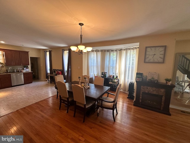 dining area featuring wood-type flooring and a notable chandelier