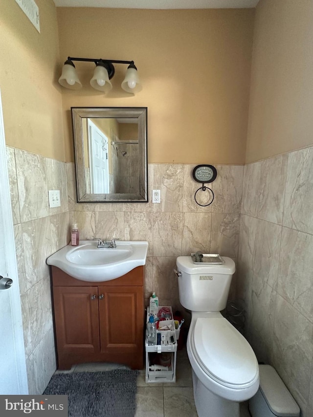 bathroom with tile walls, tile patterned floors, vanity, and toilet