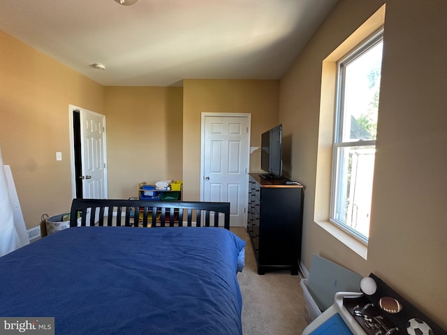 bedroom with light carpet and multiple windows