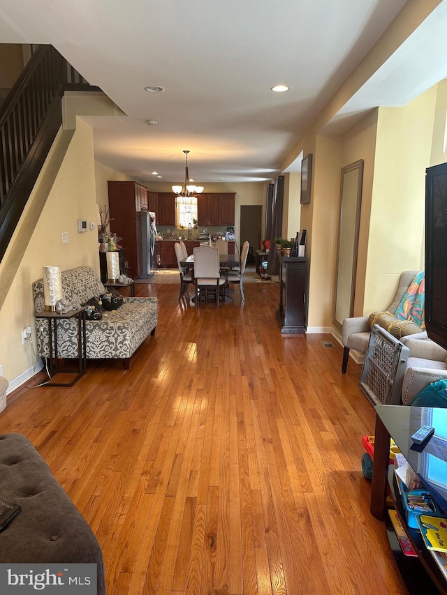 living room with a notable chandelier and light hardwood / wood-style floors