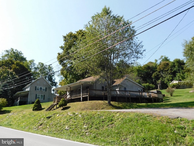 view of front of property featuring a front yard, stairway, and a wooden deck