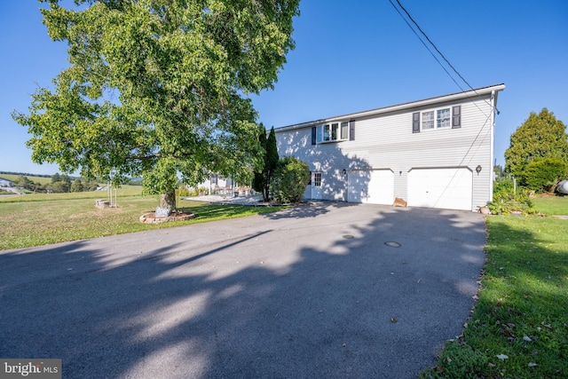 view of front of home with a front lawn and a garage