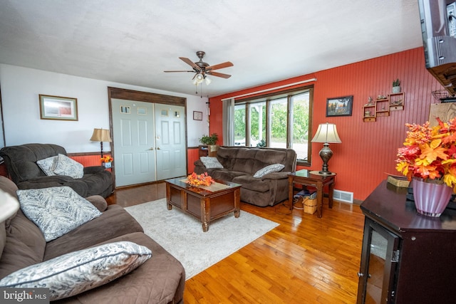 living room featuring a textured ceiling, hardwood / wood-style floors, and ceiling fan