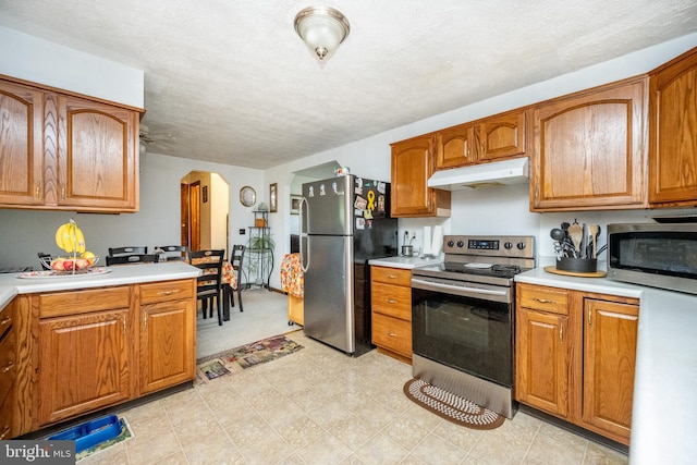 kitchen with a textured ceiling and stainless steel appliances