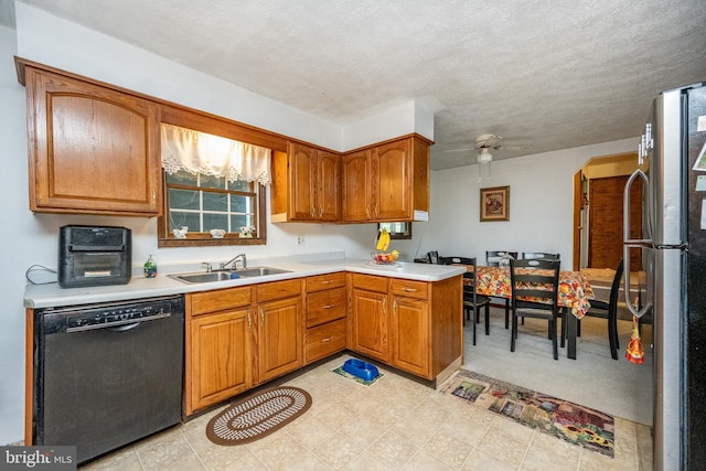 kitchen with dishwasher, sink, kitchen peninsula, ceiling fan, and stainless steel fridge