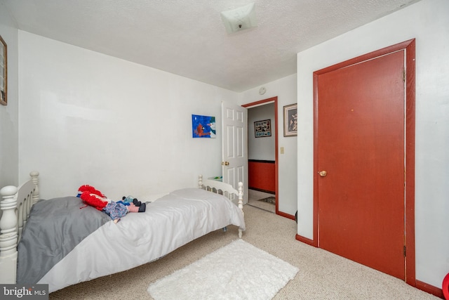 carpeted bedroom featuring a textured ceiling