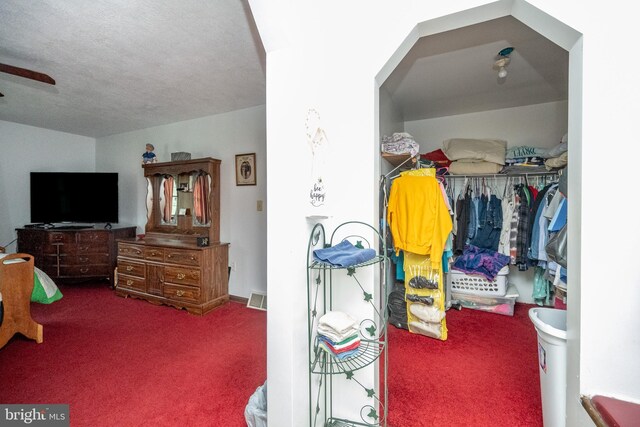 carpeted bedroom with a closet, a textured ceiling, and visible vents