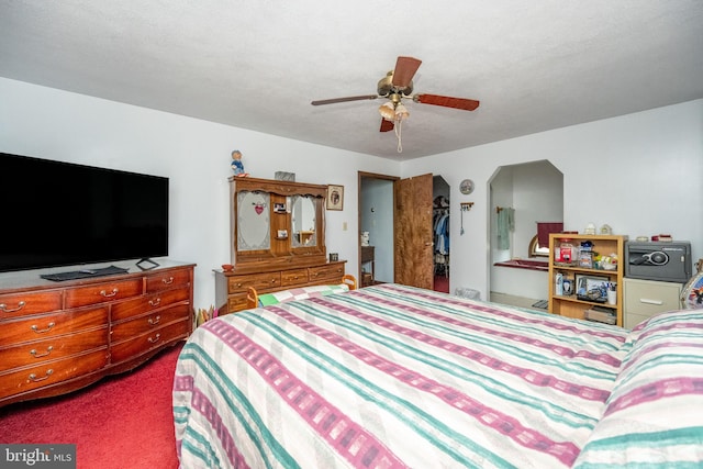 carpeted bedroom featuring a textured ceiling and ceiling fan