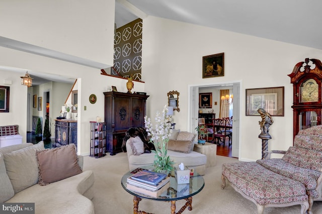 carpeted living room with beamed ceiling and high vaulted ceiling