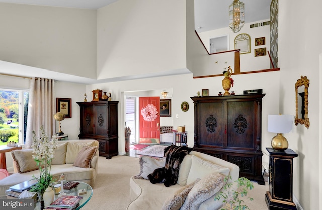 living room with light colored carpet and a high ceiling