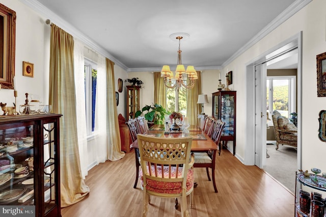 dining room featuring light hardwood / wood-style flooring, ornamental molding, and a chandelier