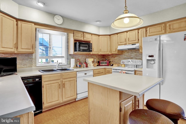 kitchen with decorative light fixtures, black appliances, a kitchen bar, a center island, and sink