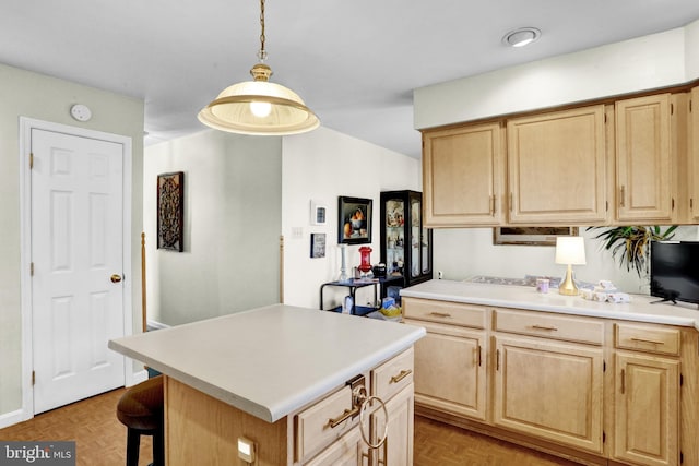 kitchen with light parquet floors, a kitchen island, light brown cabinets, and hanging light fixtures