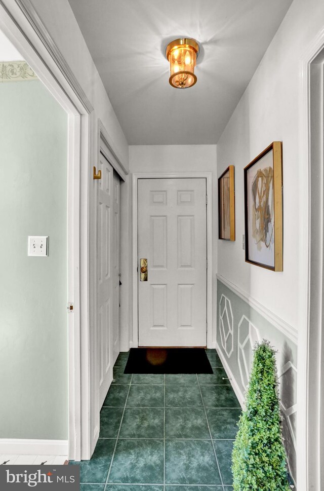 hallway featuring dark tile patterned floors